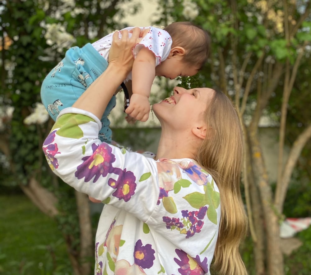 Frau hält Kleinkind hoch