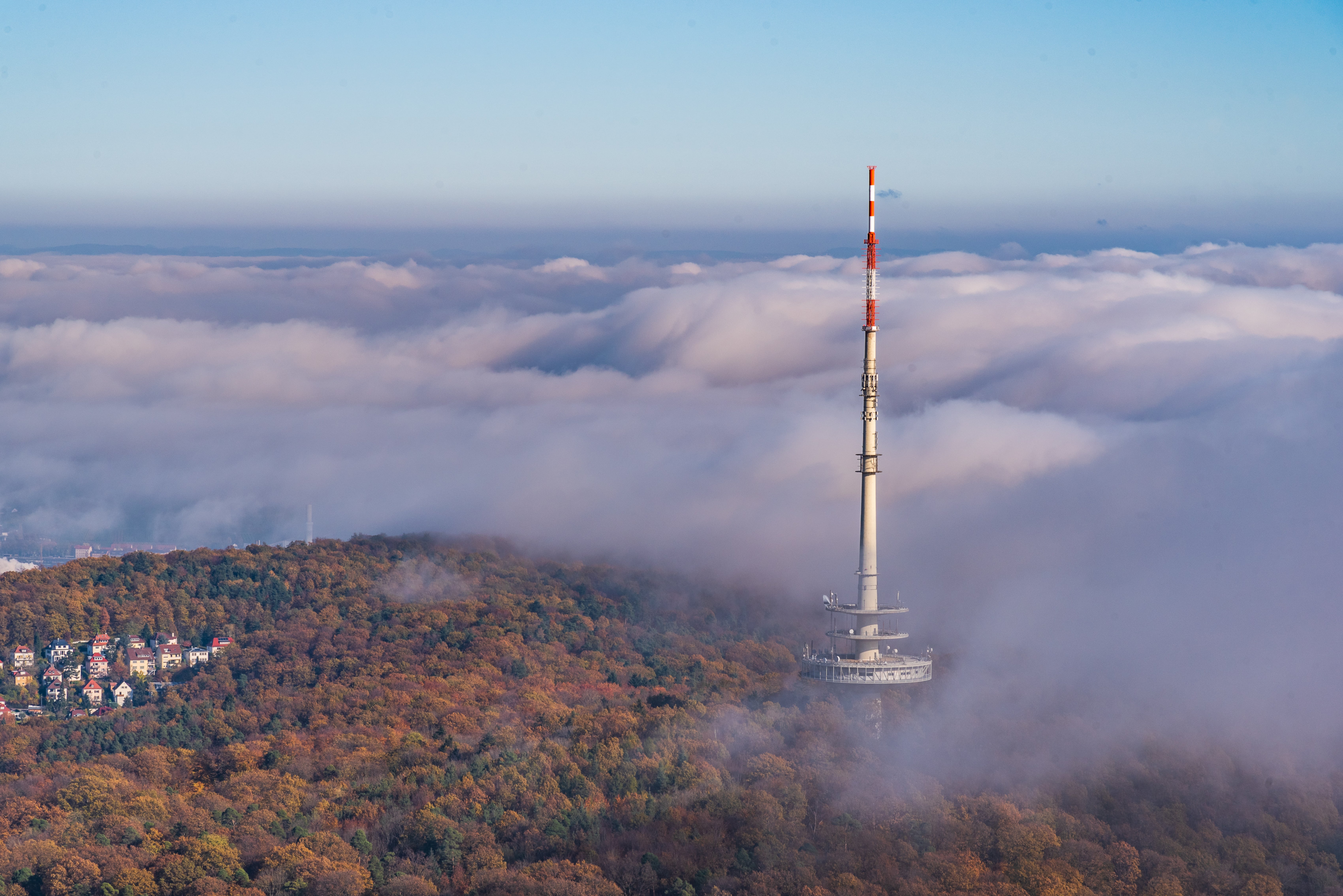 Luftaufnahme: Fernsehturm aus den Wolken aufragend